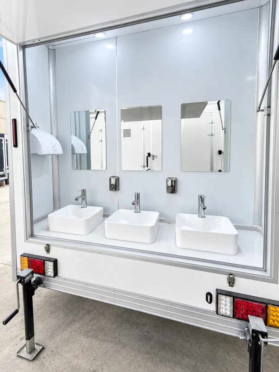 Handwashing sinks and mirrors at the end of a shower trailer
